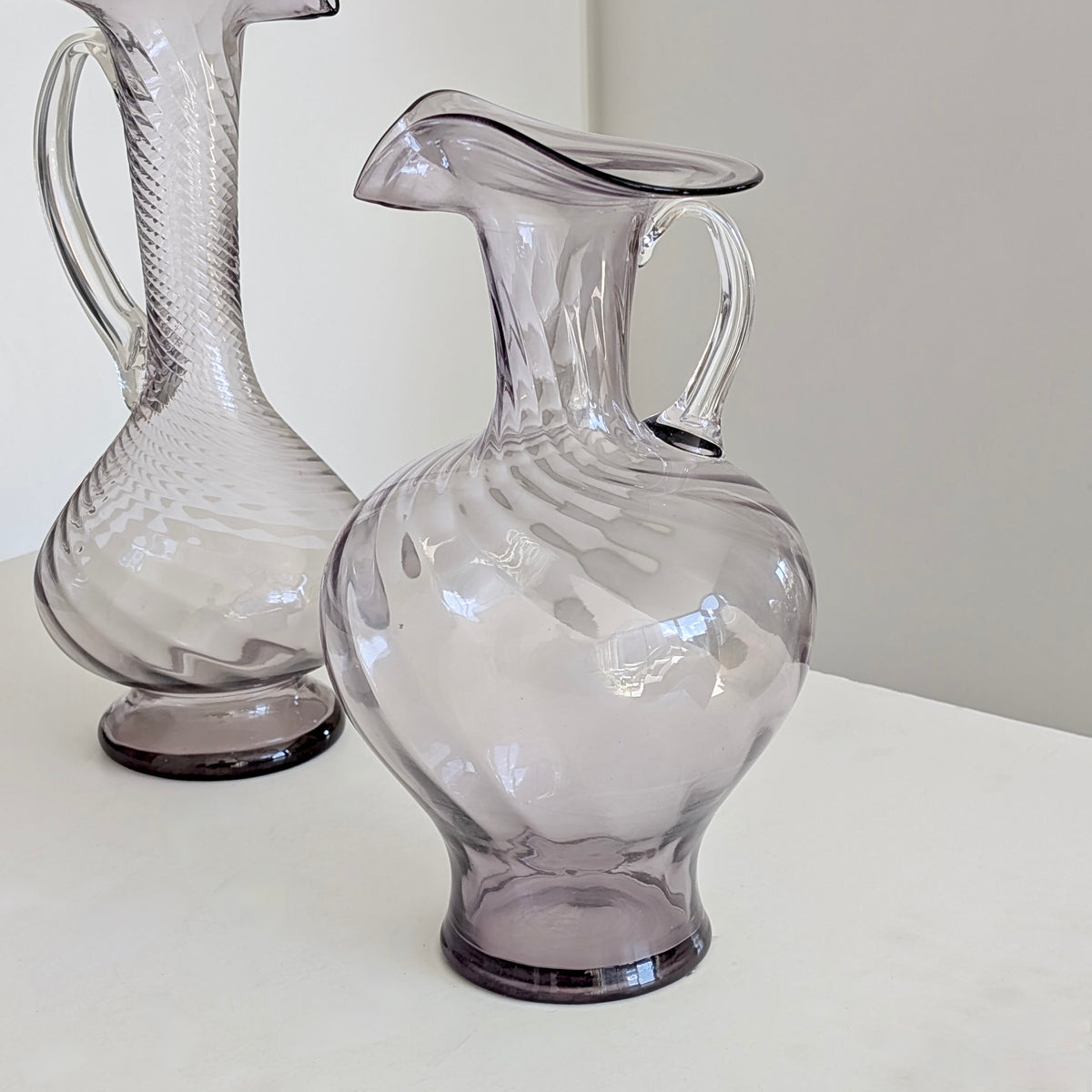 Two Large Purple Glass Pitchers