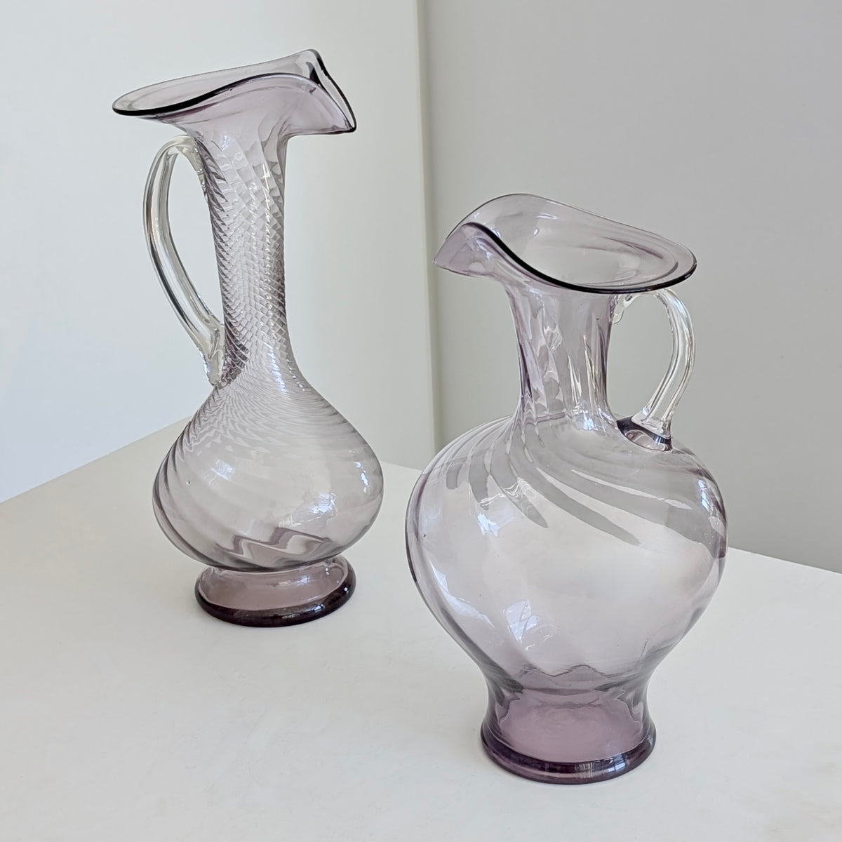 Two Large Purple Glass Pitchers