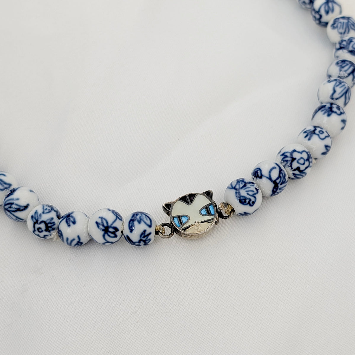 A Long Strand of Chinese Porcelain Beads with a Silver Cat Clasp, c1970's