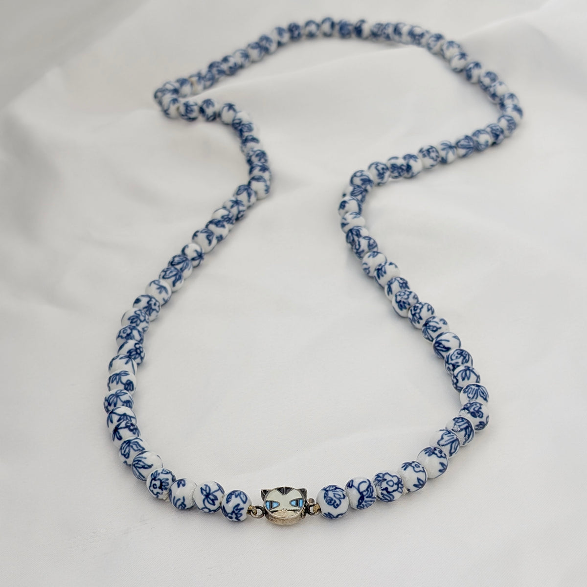 A Long Strand of Chinese Porcelain Beads with a Silver Cat Clasp, c1970's