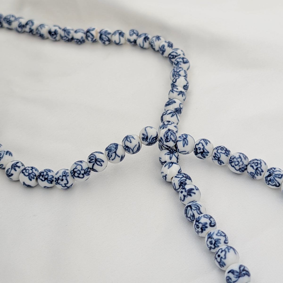 A Long Strand of Chinese Porcelain Beads with a Silver Cat Clasp, c1970's