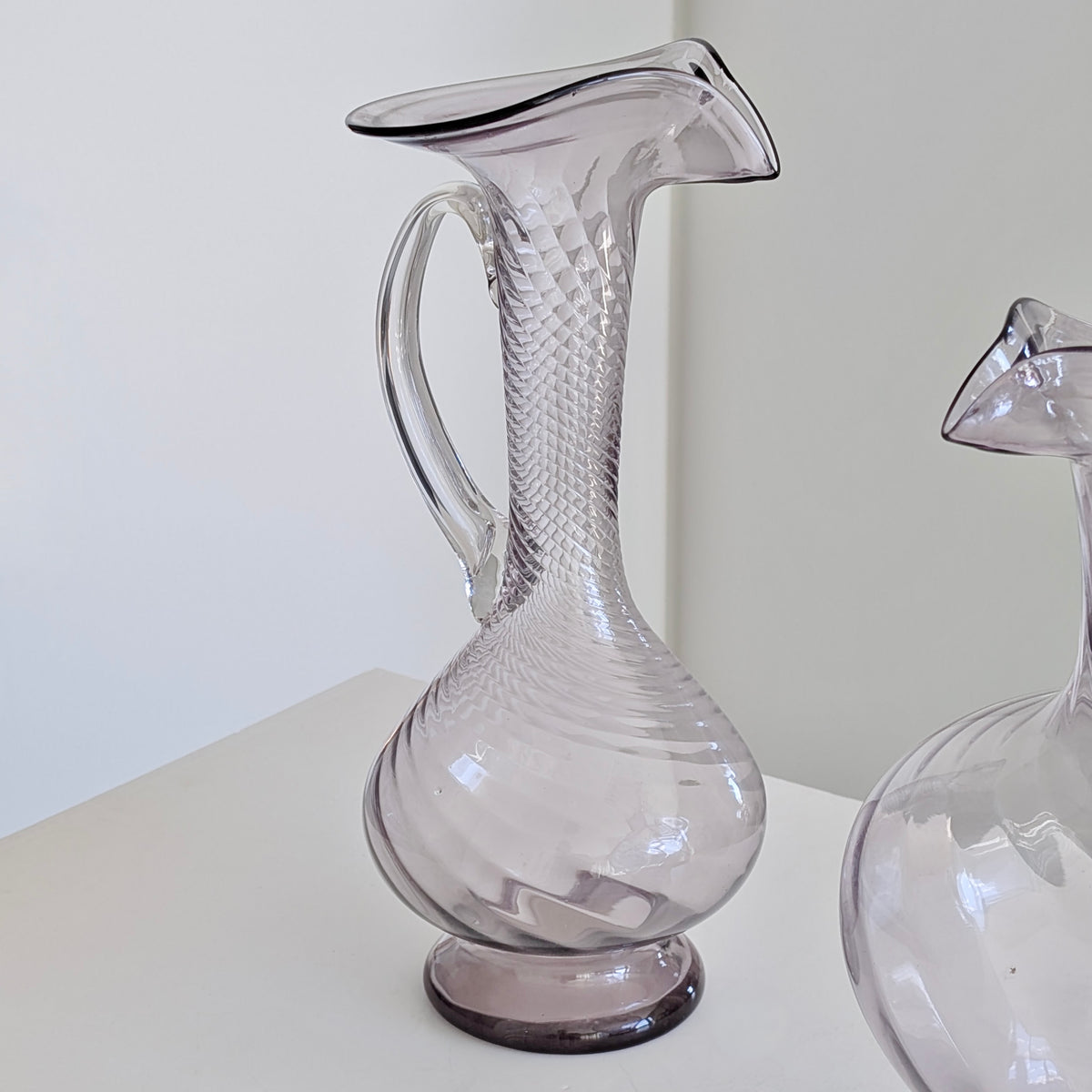 Two Large Purple Glass Pitchers