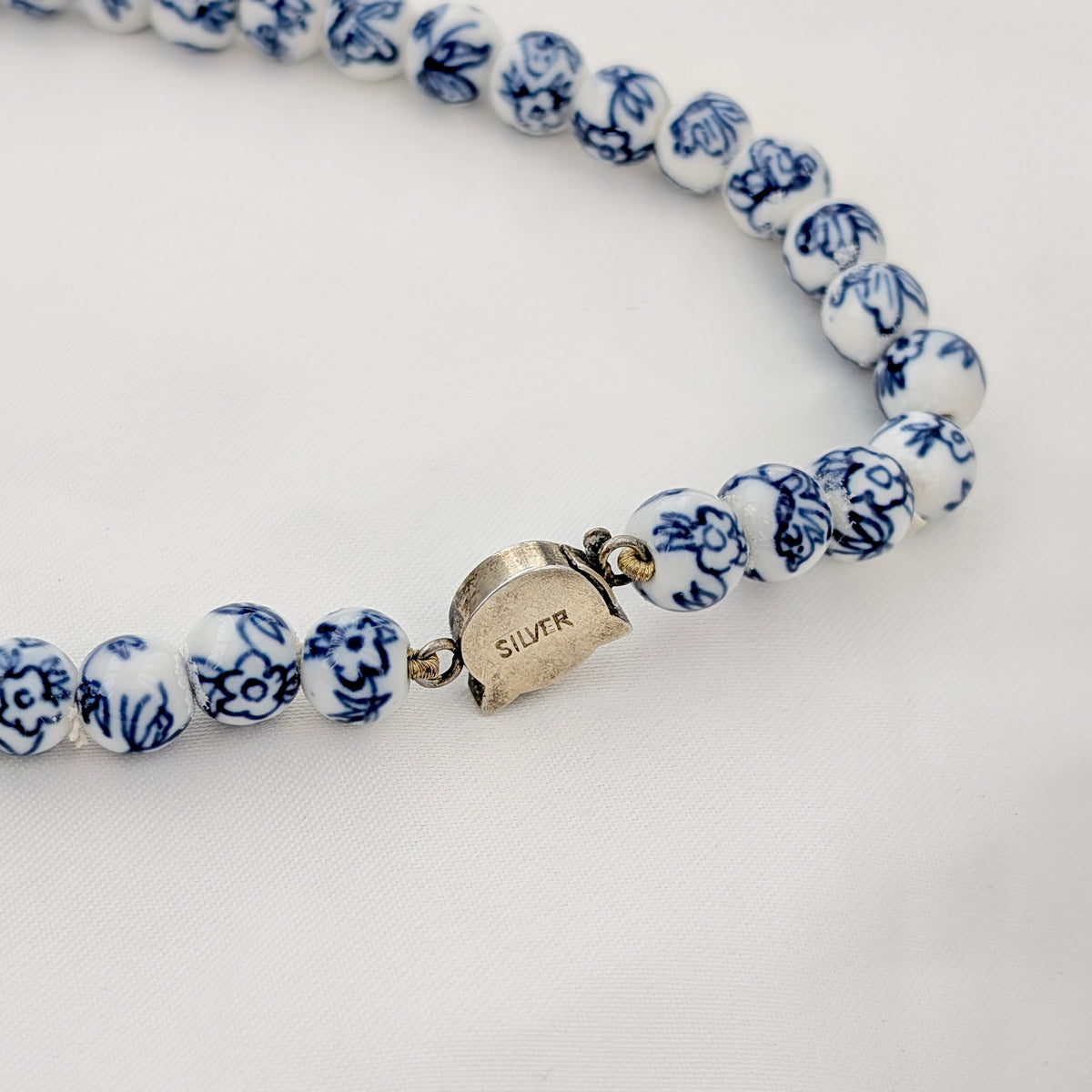 A Long Strand of Chinese Porcelain Beads with a Silver Cat Clasp, c1970's